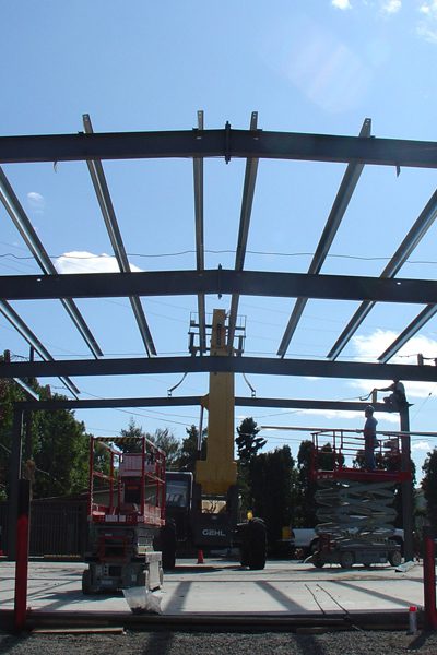 a construction site with workers working on a metal structure